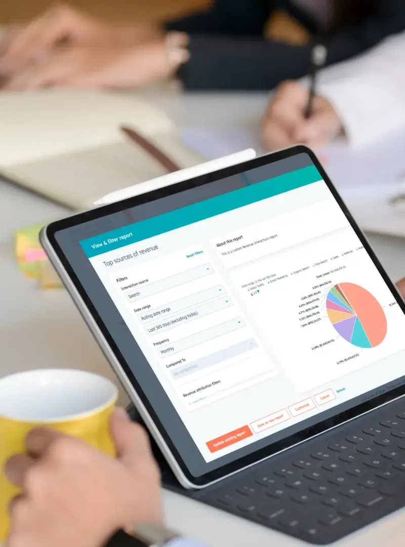 Tablet displaying a CRM report with pie charts and graphs in a business meeting. Tablet displaying a CRM report with pie charts and graphs in a business meeting.